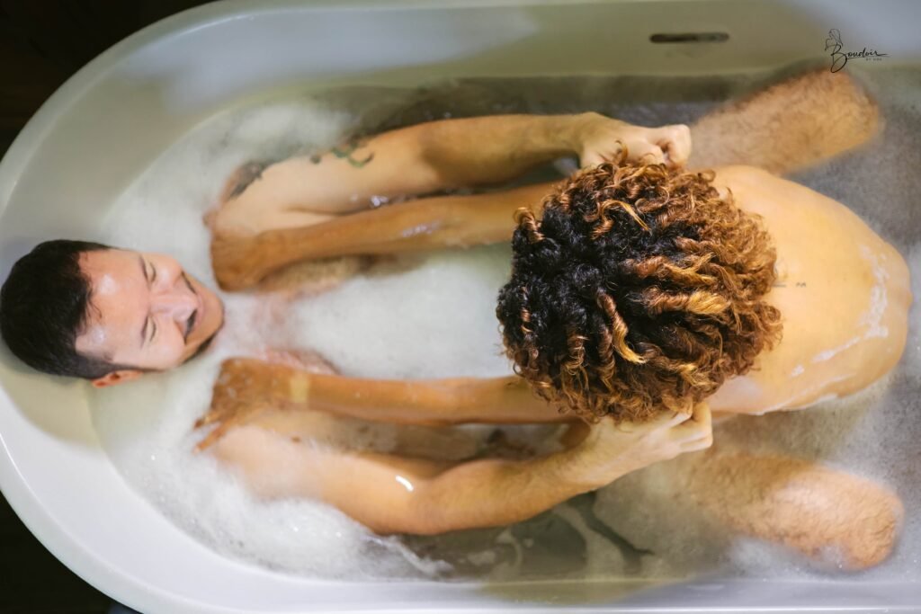 Wendy et Eric allongés ensemble dans un bain moussant, photographiés du dessus.